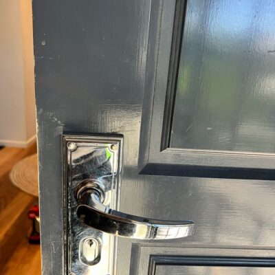 Close-up view of a door with a metallic handle and lock mechanism.
