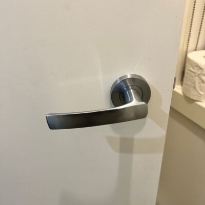 White door with modern stainless steel lever-style handle