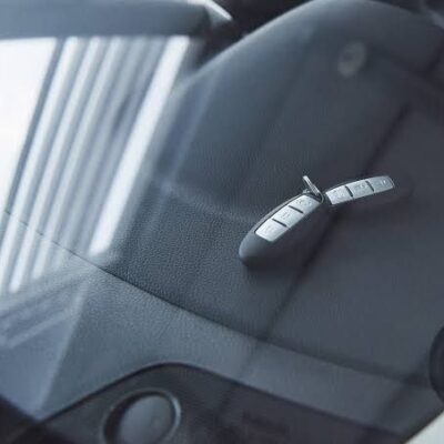 Car keys locked inside a vehicle, placed on the dashboard and viewed through the windshield.