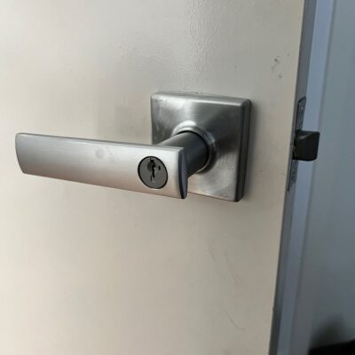 Newly installed Kwikset lever handle on a white door