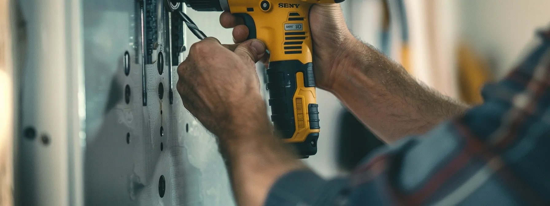 a person carefully drills holes in a sturdy wall, preparing to securely mount a keysafe for optimal security and ease of access.