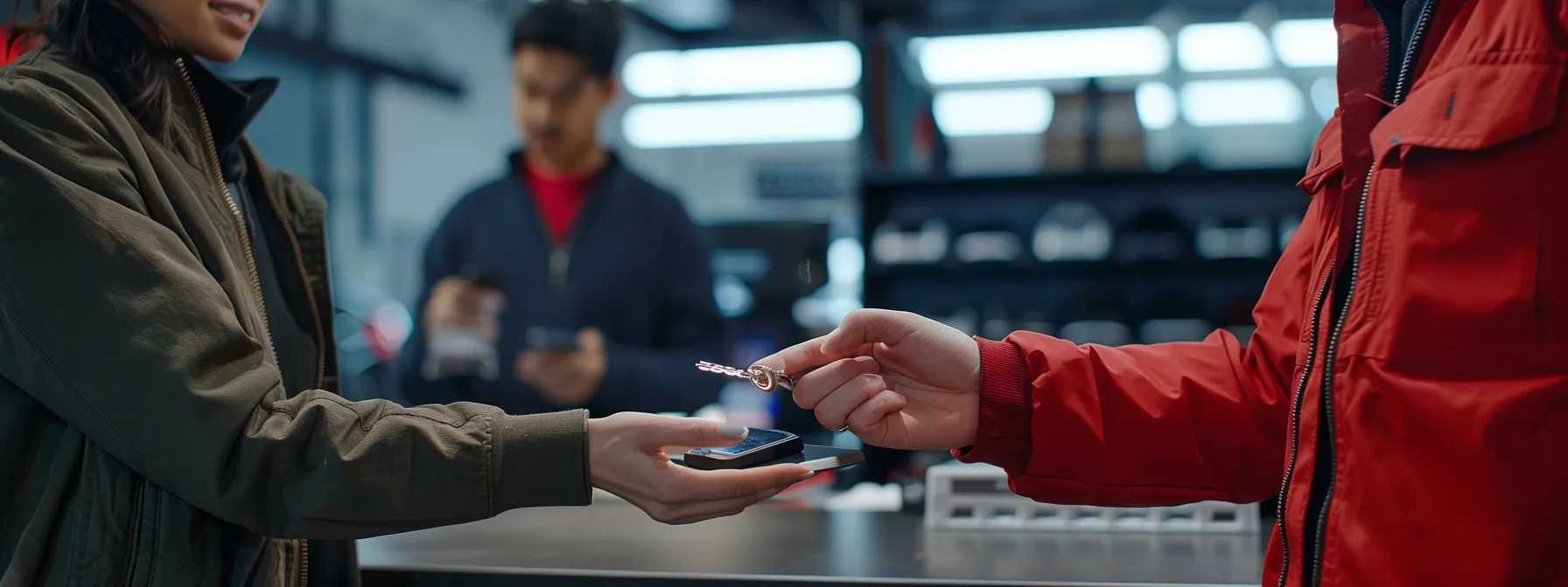 a person standing at a dealership counter, holding out their hand to receive a new smart key replacement, with a friendly service representative assisting them.